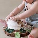Capture the joy of a baby experiencing a cake smash, making delightful mess and memories.