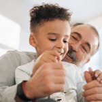 Grandfather and grandson sharing a joyful moment together indoors.