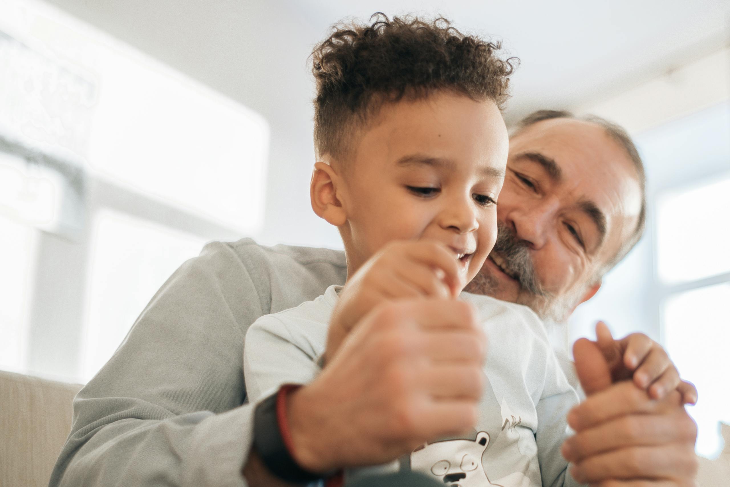 Grandfather and grandson sharing a joyful moment together indoors.
